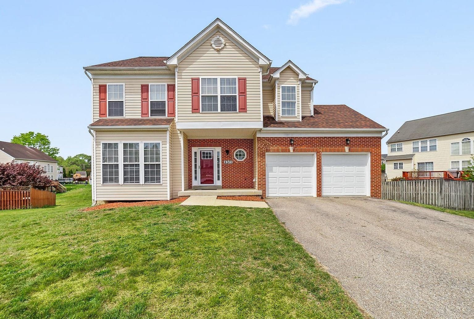 Renovated two-story colonial with brick garage elevation in Clinton, Maryland